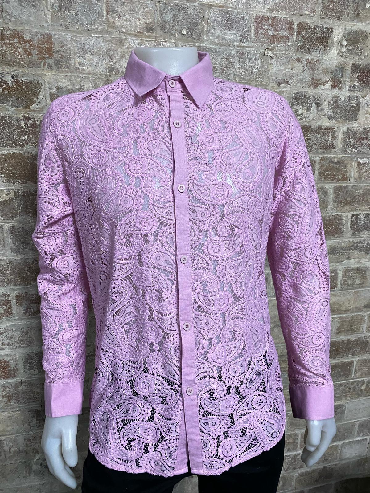 Pink paisley patterned shirt on a mannequin against a brick wall.
