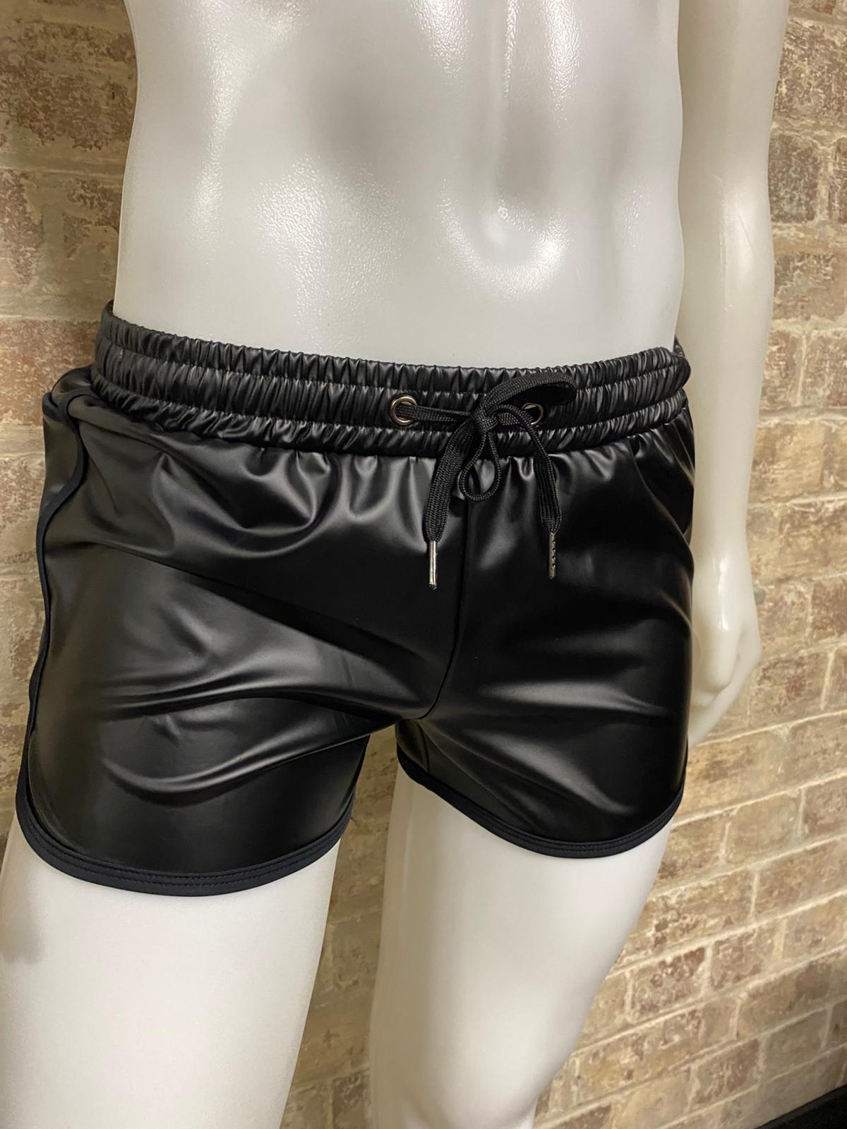Manequin in shorts in front of brick wall.