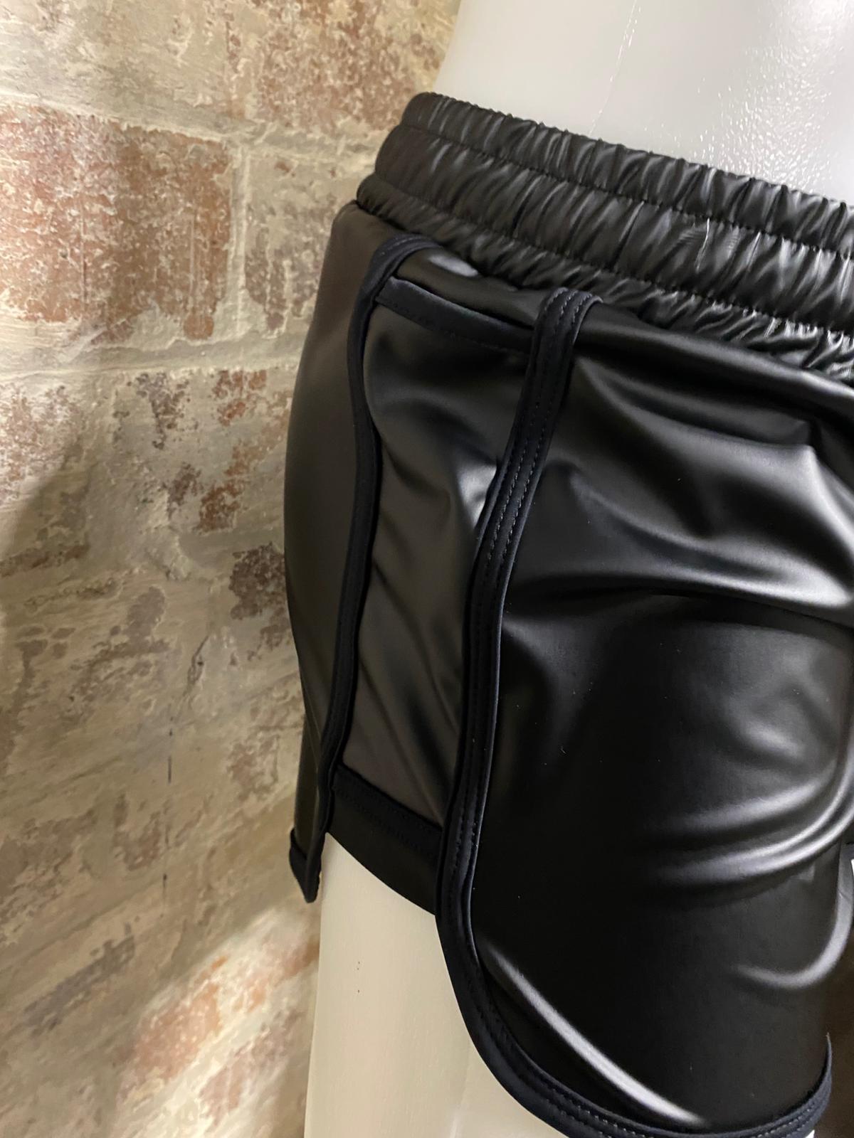 Side view of manequin in front of brick wall wearing shorts